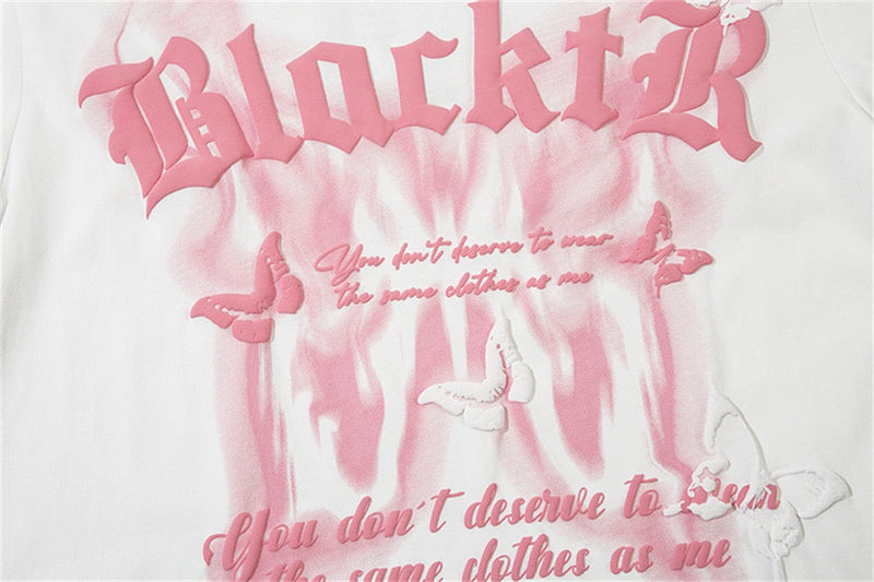 White graphic tee with pink Gothic lettering, butterfly prints, and a dark romantic streetwear slogan design