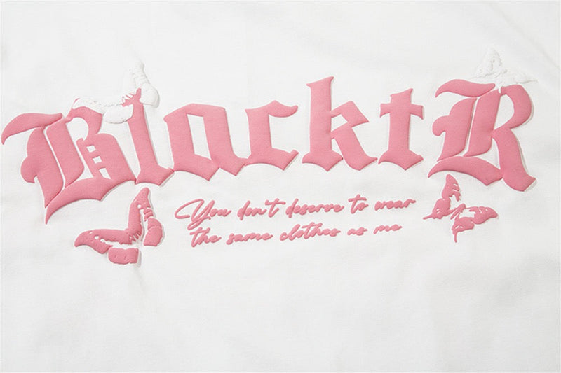 White graphic tee with pink gothic lettering, butterflies, and a romantic slogan across the chest