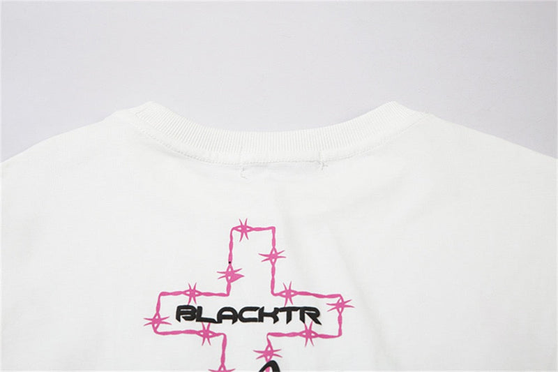 White oversized tee with pink flame cross graphic and black BLACKTR lettering on the back neckline