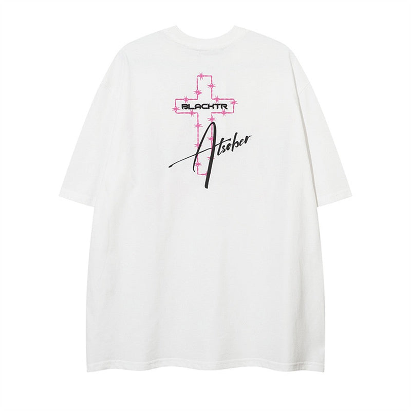White oversized graphic tee with pink cross and black script print on the chest, Y2K streetwear style