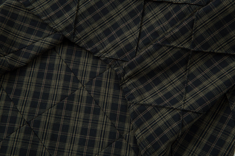 Close-up of black plaid quilted fabric with diagonal diamond stitching