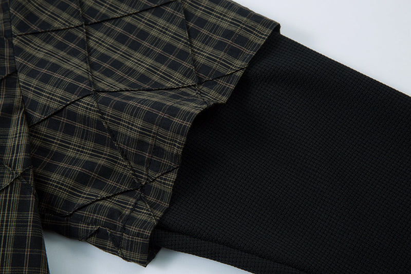 Close-up of shirt cuff layered over a black textured long sleeve