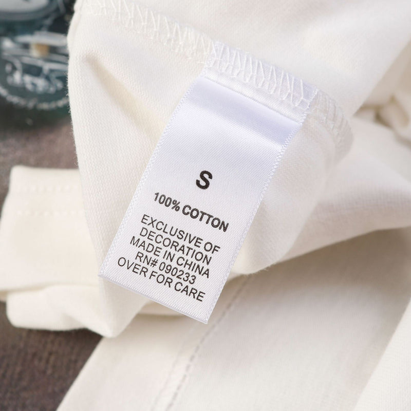 Close-up of white cotton streetwear tee with size S care label and visible seam detail