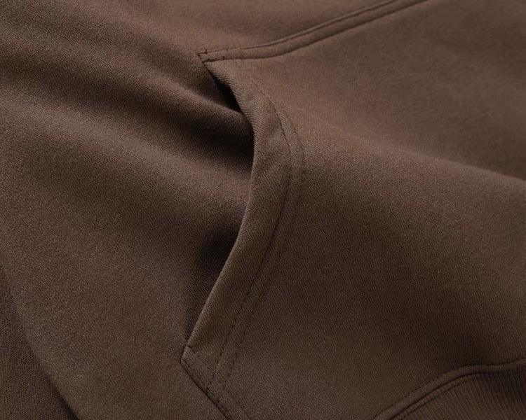 Brown hoodie kangaroo pocket seam close-up