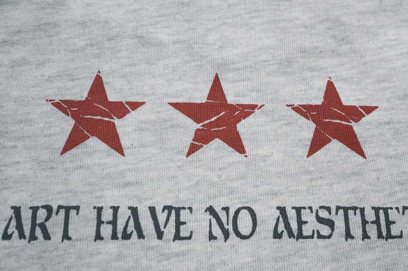 Gray streetwear tee with three red star graphics and distressed black lettering on cotton fabric