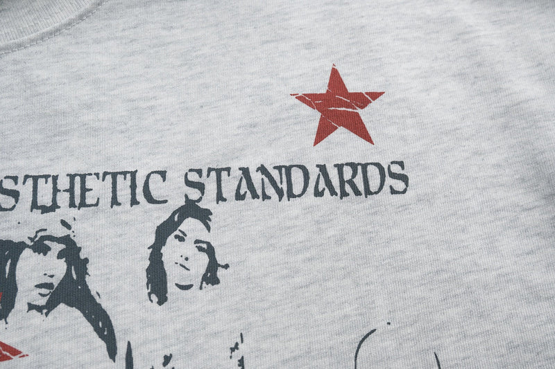Close-up of a white graphic streetwear tee with red star and collage-style print of faces and text across the chest