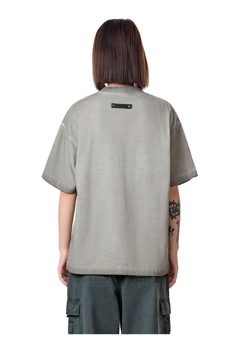 Back view of a vintage washed gray heavyweight tee with rivet detail, worn by a model on a plain white background