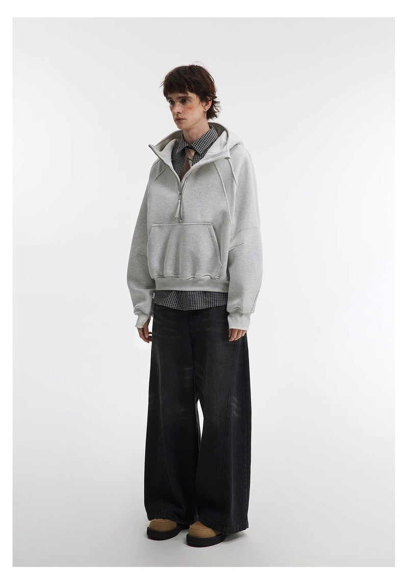 Light gray cropped hoodie worn over check shirt and tie, side view