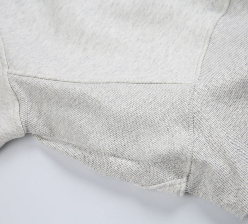 Close-up of light gray hoodie sleeve and side seam