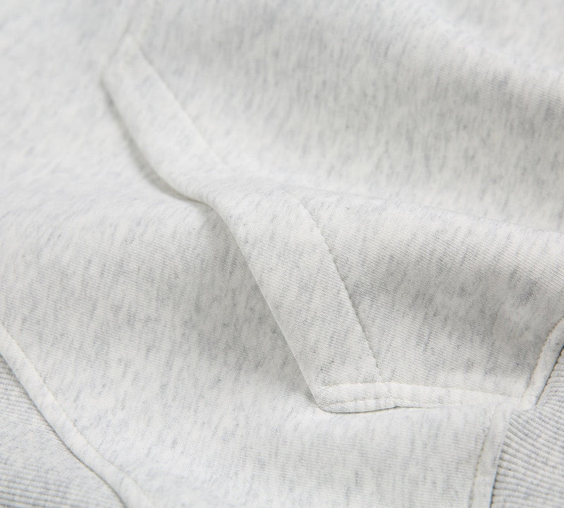 Close-up of light gray kangaroo pocket and front seam details