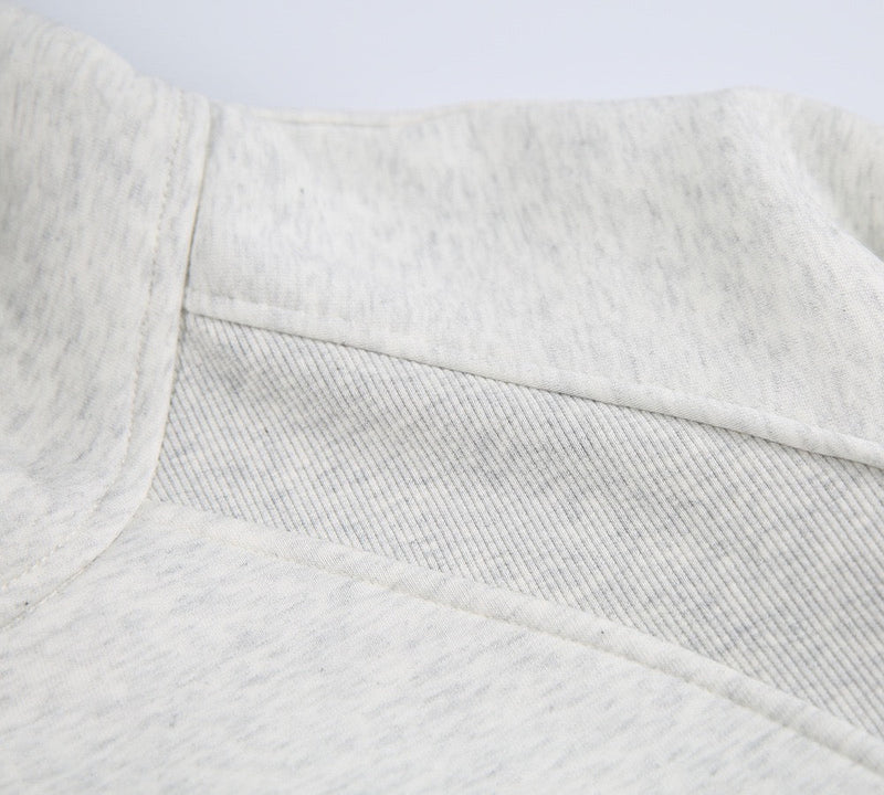 Close-up of light gray hoodie upper back seam and hood lining
