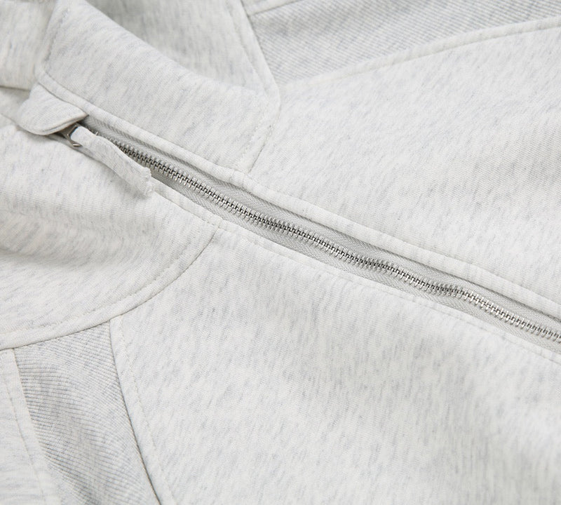 Close-up of light gray half-zip front and kangaroo pocket seam