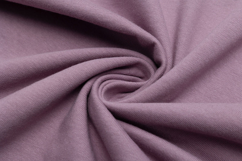 Close-up of soft mauve fabric with a smooth knit texture, showing the material used for an oversized streetwear tee