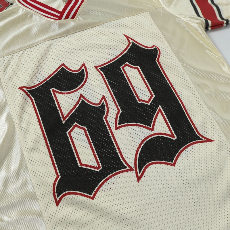 Cream retro football jersey tee with large gothic black lettering and red trim on textured mesh fabric