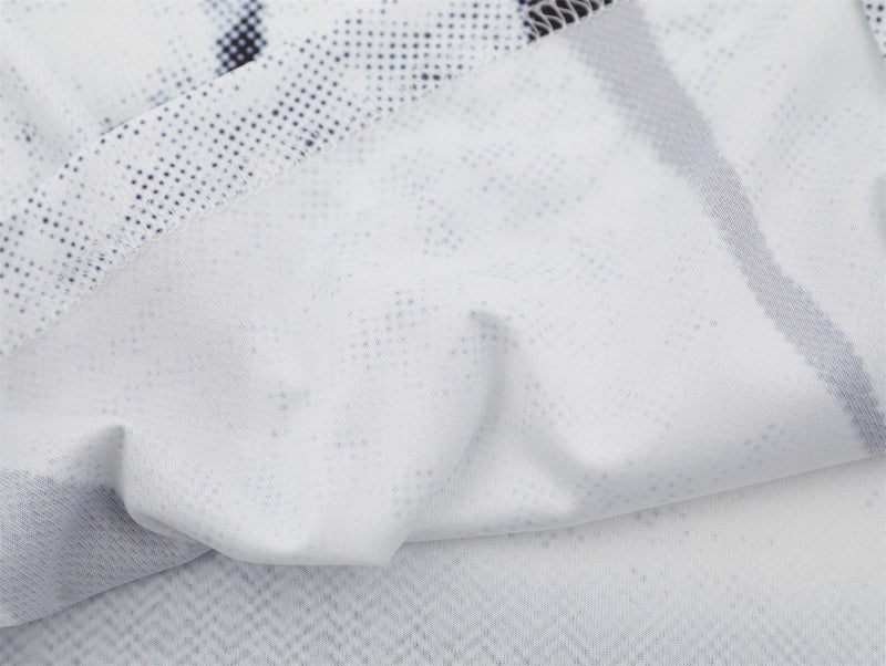 Close-up of white distressed mesh jersey fabric with dotted soccer shirt texture and soft folds