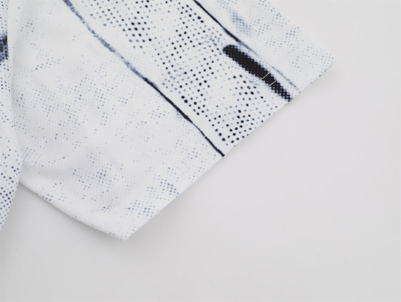 Close-up of a gray and white distressed mesh jersey tee with black speckled pattern and folded hem