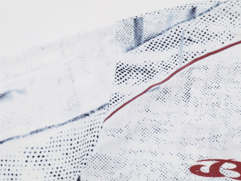 Close-up of a white distressed mesh soccer jersey tee with black speckled pattern and red trim accents