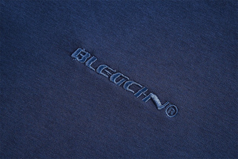 Close-up of embroidered brand text on navy sweatshirt fabric