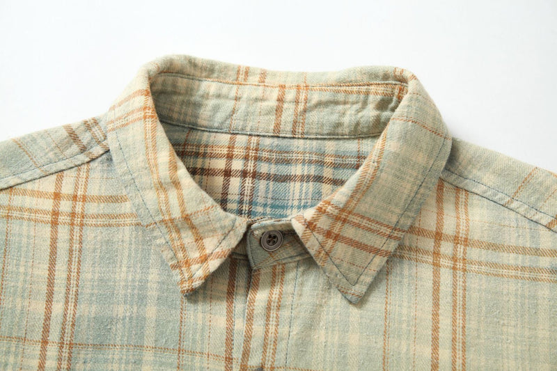 Close-up of the plaid shirt collar and top button on cream and tan checks