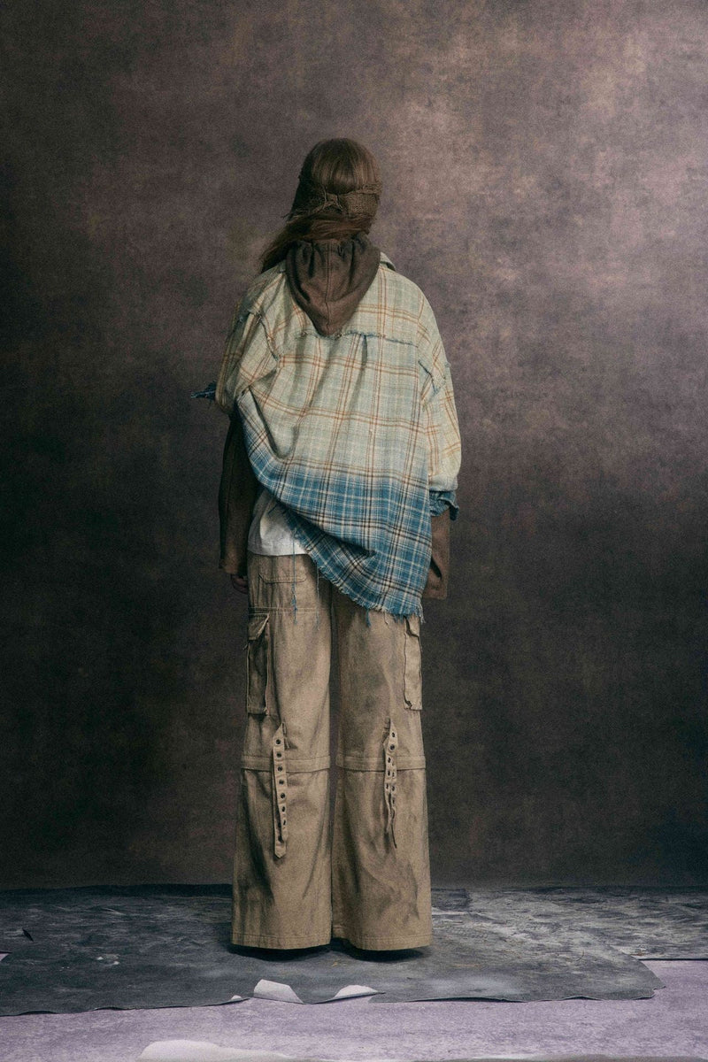 Back view of the plaid flannel shirt showing the loose drape and raw hem