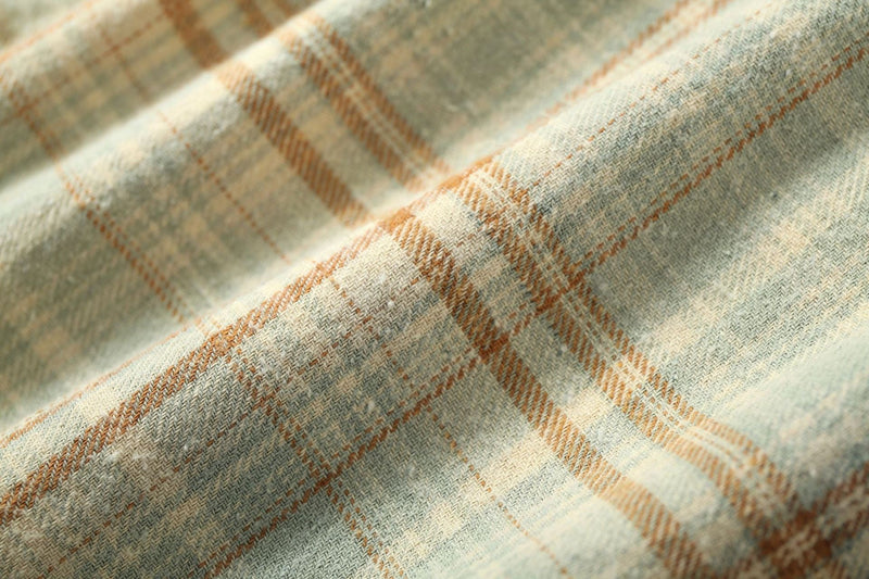 Close-up of cream plaid flannel fabric with tan lines and soft texture