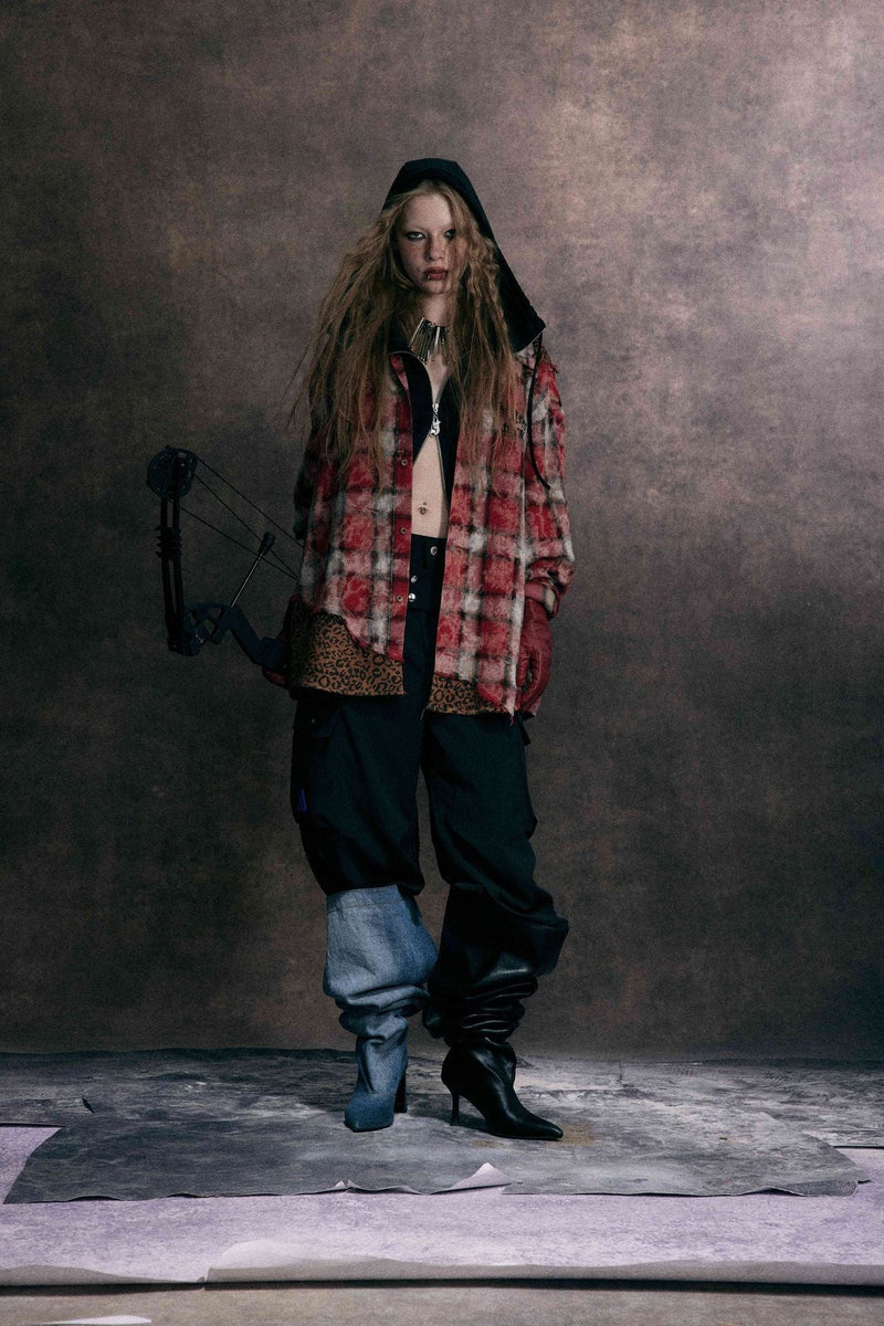 Model wearing red plaid patchwork shirt with leopard print hem over black layers