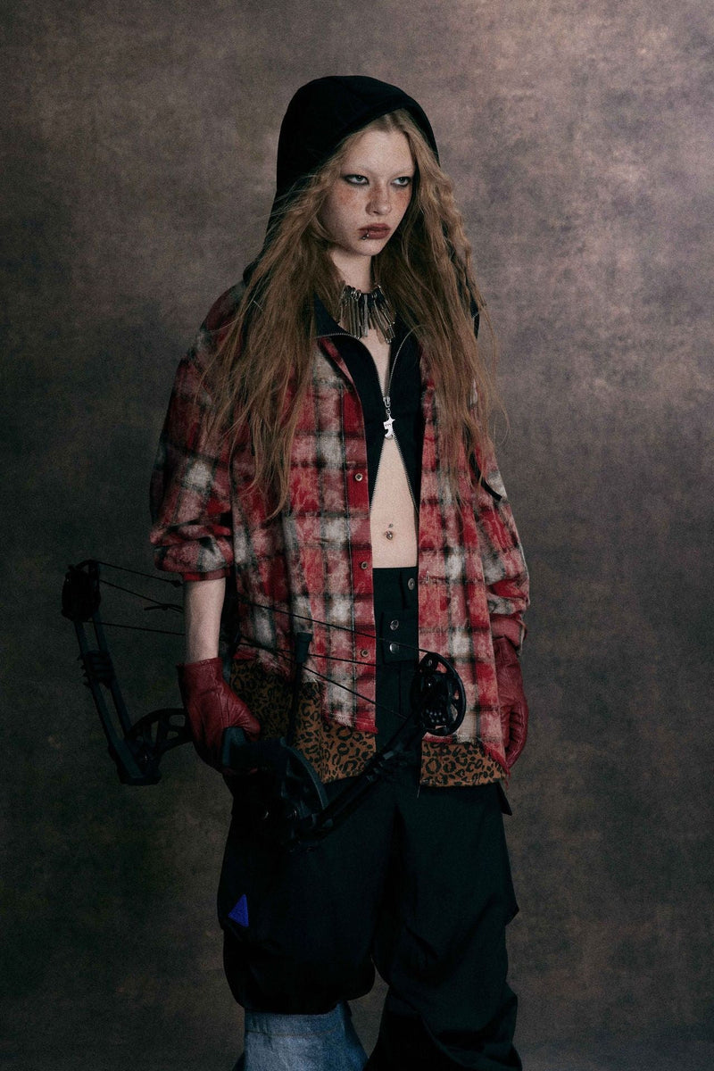 Close front view of red distressed plaid shirt with black hooded layer and leopard hem