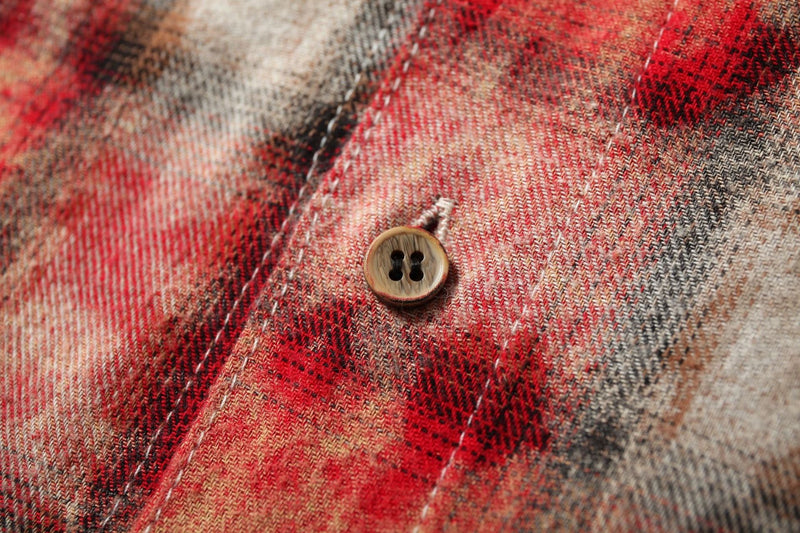 Close-up of button on red plaid patchwork fabric
