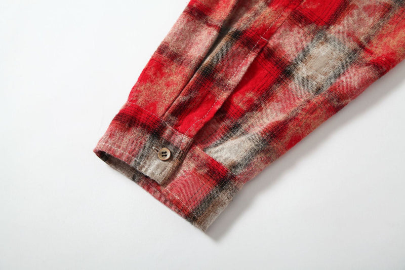 Close-up of buttoned sleeve cuff on red plaid patchwork shirt