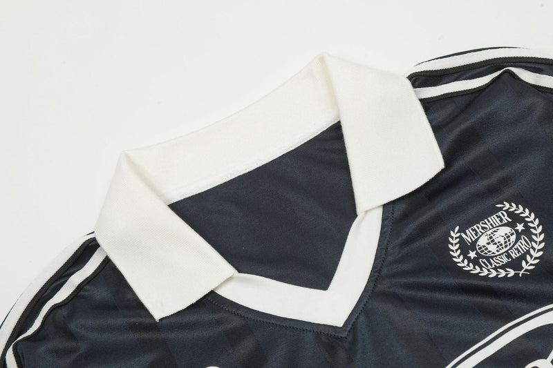 Close-up of black jersey collar with white ribbed polo collar and shoulder stripe