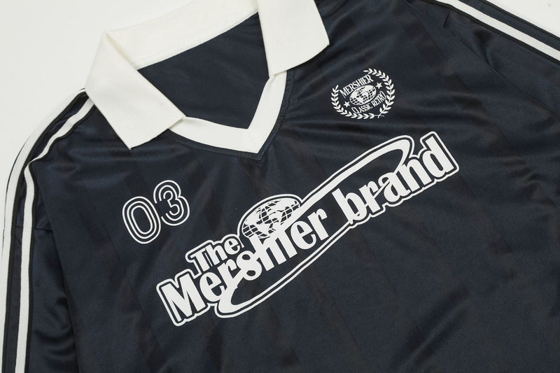 Close-up of black jersey front graphic and collar with white printed crest and number 03