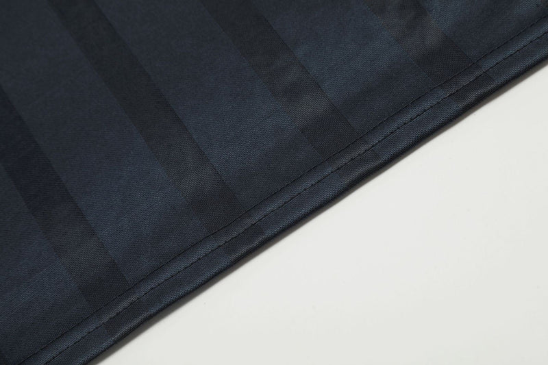 Close-up of black jersey hem stitching and smooth woven fabric