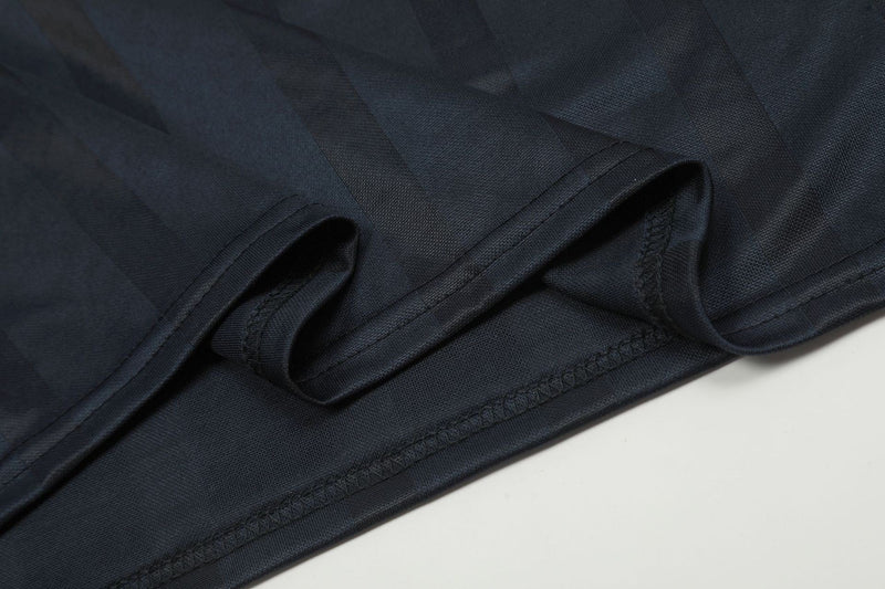 Close-up of black jersey sleeve cuff and lower seam with folded fabric