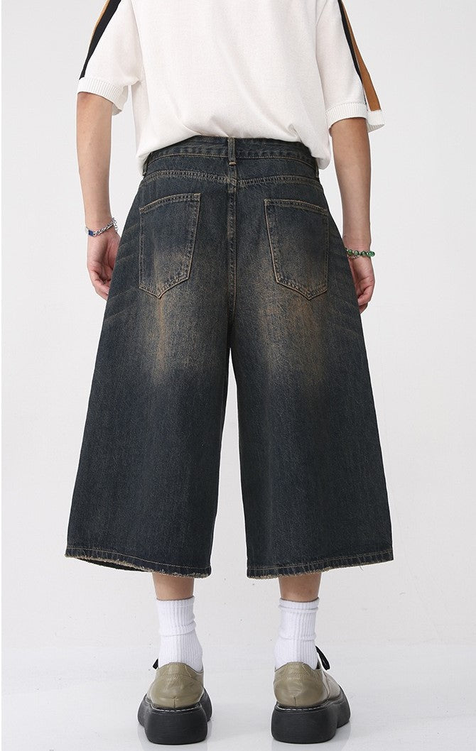 Back view of dark washed wide-leg denim shorts with two back patch pockets