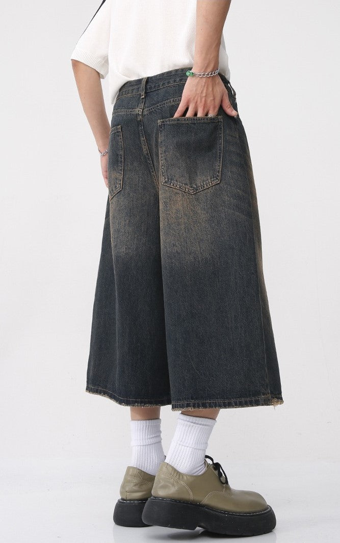 Side and back view of dark washed wide-leg denim shorts with wide cropped leg