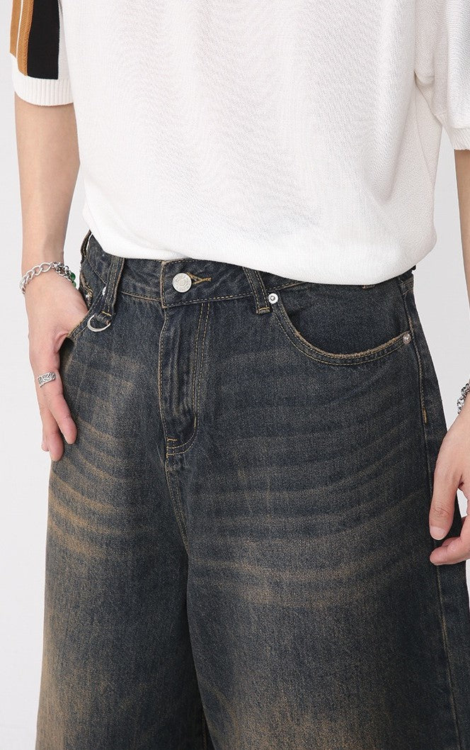 Close-up of dark washed denim shorts waistband and front pocket detail