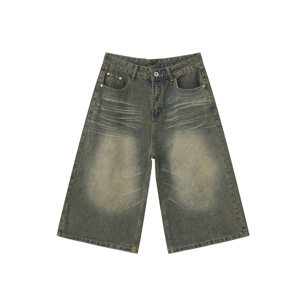Flat lay of wide-leg vintage wash denim shorts with sun-faded amber and slate blue tones, five-pocket design