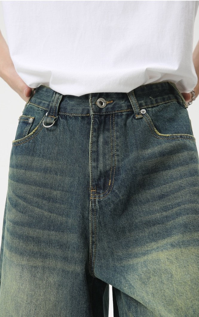 Close-up of the denim shorts waistband and front zipper area in vintage wash denim
