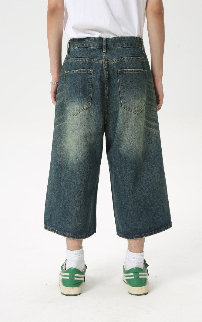 Wide leg vintage wash denim shorts in dark blue, back view on a model