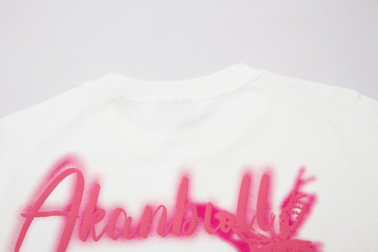 White oversized graphic tee with pink graffiti-style lettering and butterfly print on the back រូ