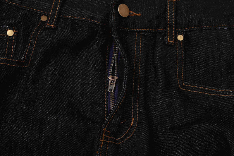Close-up of dark indigo denim jorts front zipper fly and button closure