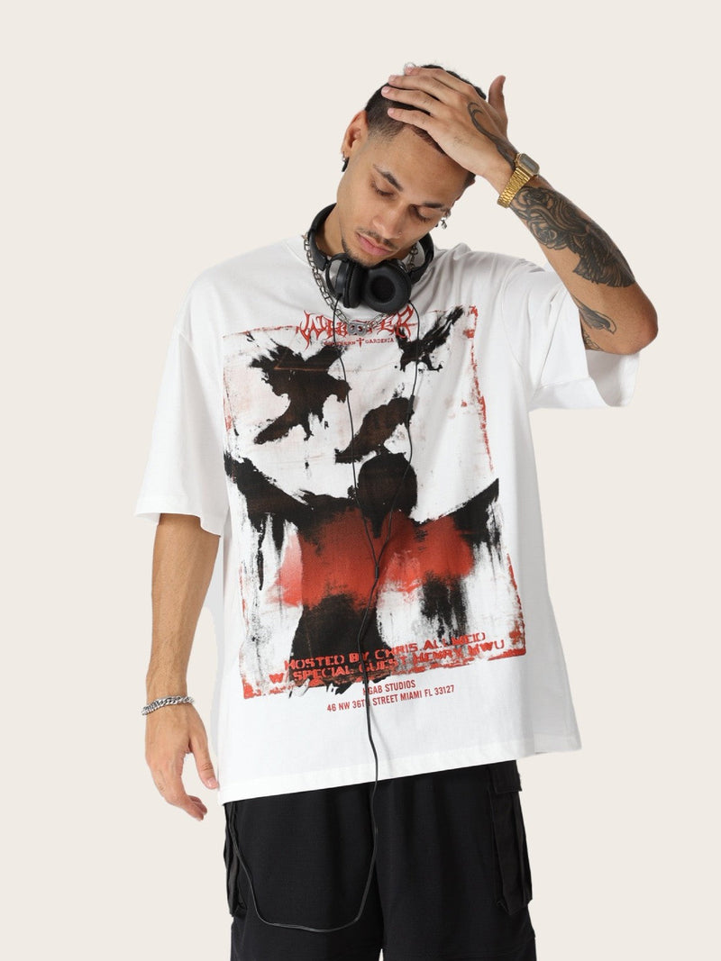 Model wearing oversized white tee with distressed black raven graphic and red accents, styled with headphones and cargo pants