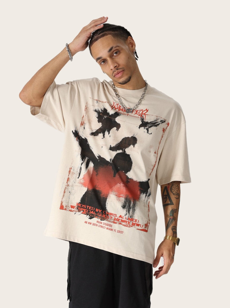 Oversized beige tee with distressed raven graphic and red gothic text, styled on a model with streetwear layering