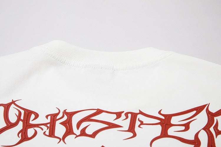 White oversized tee with distressed red gothic graphic lettering across the chest on a clean studio background