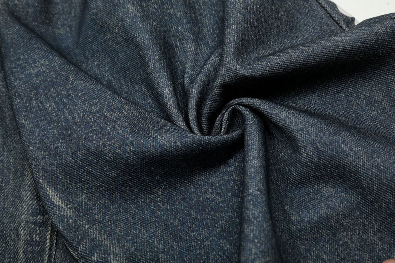 Close-up of dark denim fabric with visible weave and soft folded texture