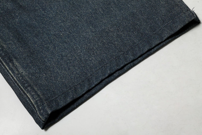 Close-up of hem on dark wash denim shorts showing heavy fabric texture and stitching