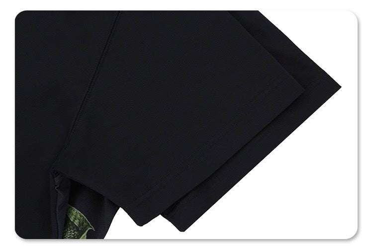 Black graphic tee with tactical vest illusion print and camouflage accent on the sleeve, shown folded on white background