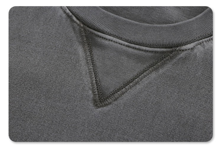 Close-up of a vintage washed gray heavyweight cotton tee with ribbed crew neck and stitched V-insert detail