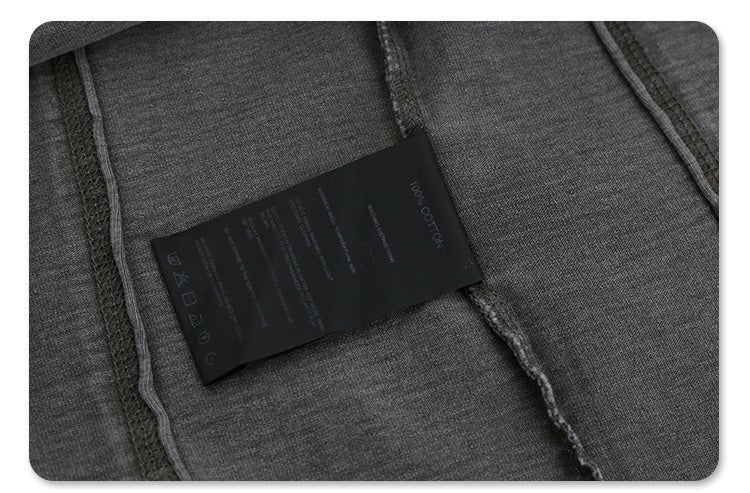 Close-up of dark gray vintage washed cotton tee with split-hem seam detail and black care label