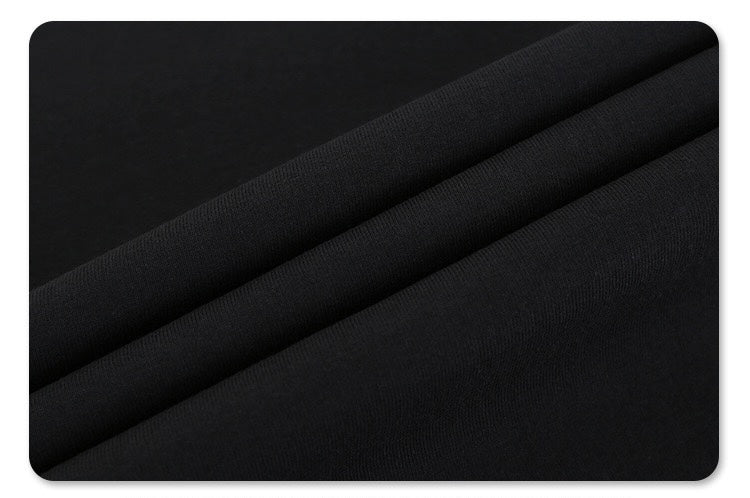 Black colorblock T-shirt fabric with diagonal panel seams and subtle textured knit, styled as futuristic streetwear